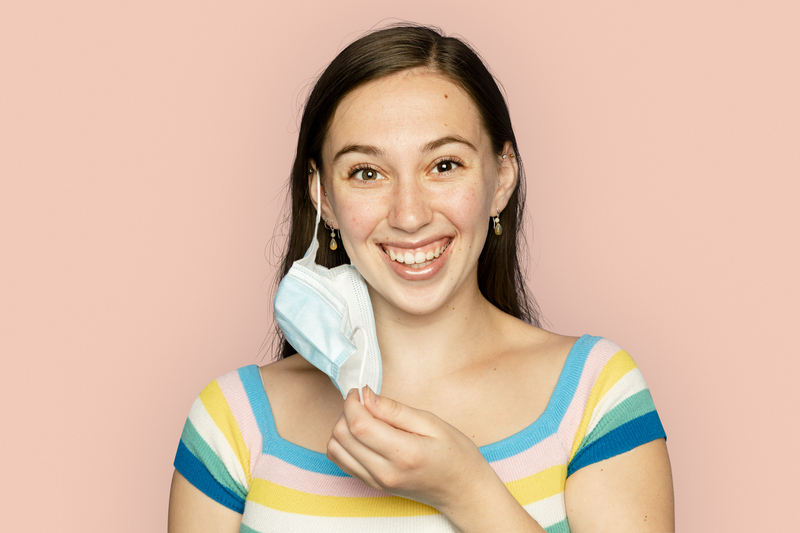 Woman taking off mask in the new normal