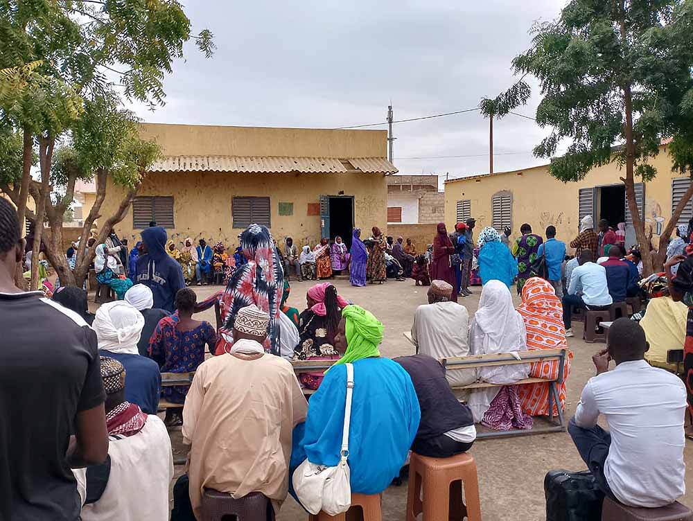 Das Bild zeigt wartende Menschen in einer Einrichtung im Senegal.