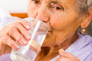 Seniorin beim Trinken von Wasser